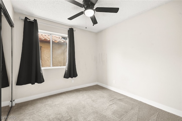 empty room featuring baseboards, a textured ceiling, ceiling fan, and carpet flooring