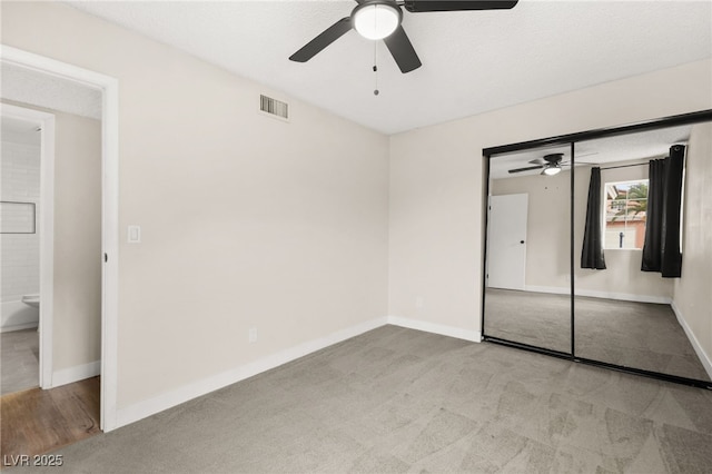 unfurnished bedroom featuring ceiling fan, carpet, visible vents, and baseboards