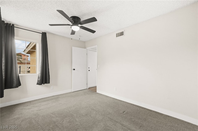 spare room with carpet flooring, ceiling fan, a textured ceiling, and visible vents