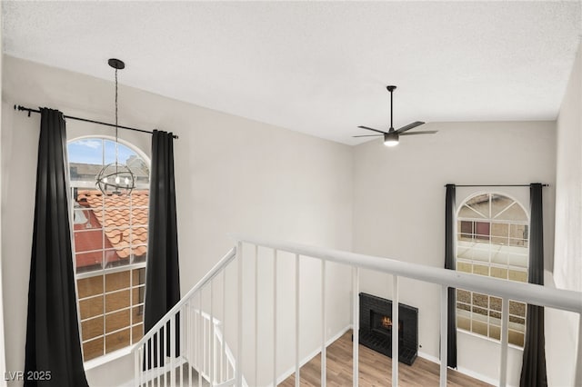 interior space featuring an upstairs landing, an inviting chandelier, and wood finished floors