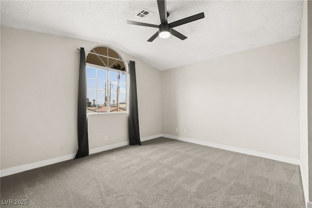 carpeted empty room with a ceiling fan, baseboards, visible vents, lofted ceiling, and a textured ceiling