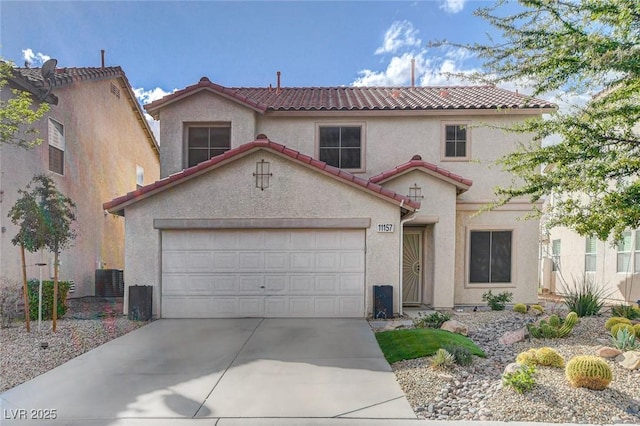 mediterranean / spanish-style home featuring concrete driveway, a tiled roof, central AC unit, and stucco siding