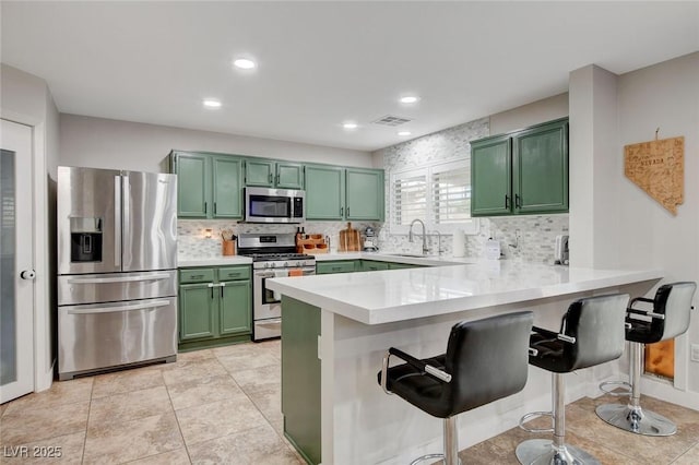 kitchen featuring visible vents, a sink, light countertops, appliances with stainless steel finishes, and green cabinets