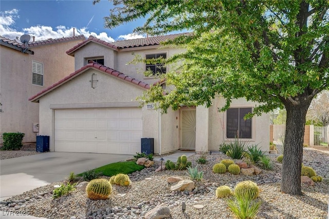 view of front of house with stucco siding, fence, concrete driveway, and a tile roof