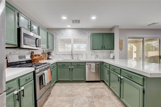 kitchen with a sink, green cabinetry, and stainless steel appliances