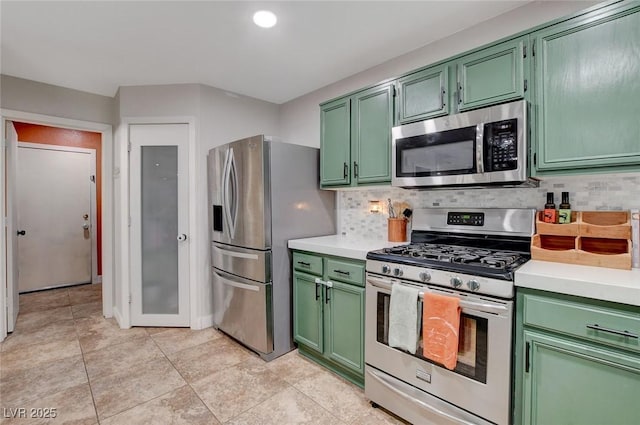 kitchen with backsplash, stainless steel appliances, green cabinets, and light countertops