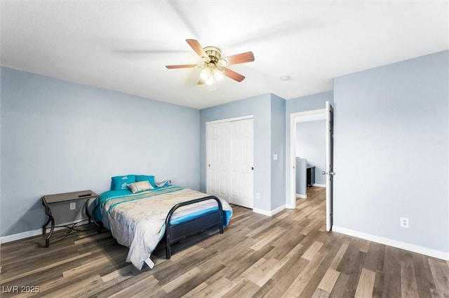 bedroom featuring ceiling fan, a closet, baseboards, and wood finished floors