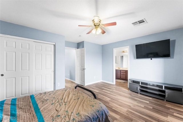 bedroom featuring visible vents, baseboards, wood finished floors, a closet, and a ceiling fan