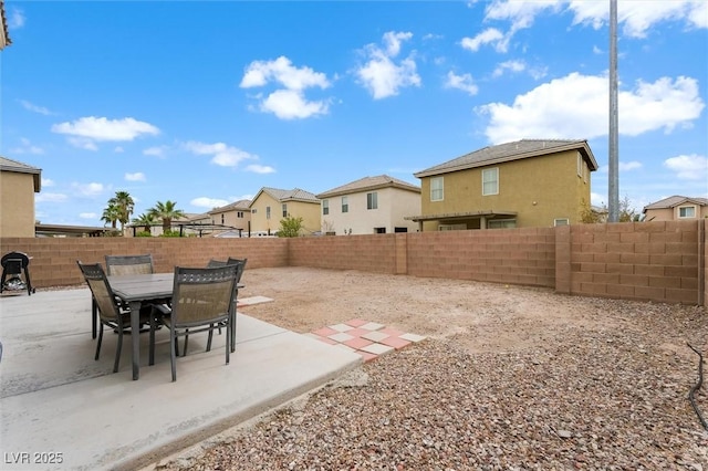 view of yard with a patio area, outdoor dining space, a residential view, and a fenced backyard