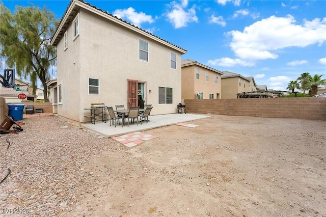 rear view of property with a patio area, stucco siding, and a fenced backyard