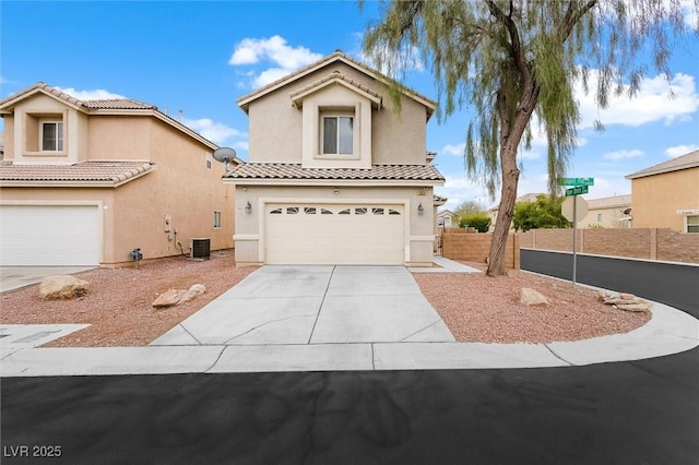 mediterranean / spanish-style house with stucco siding, a garage, driveway, and a tile roof