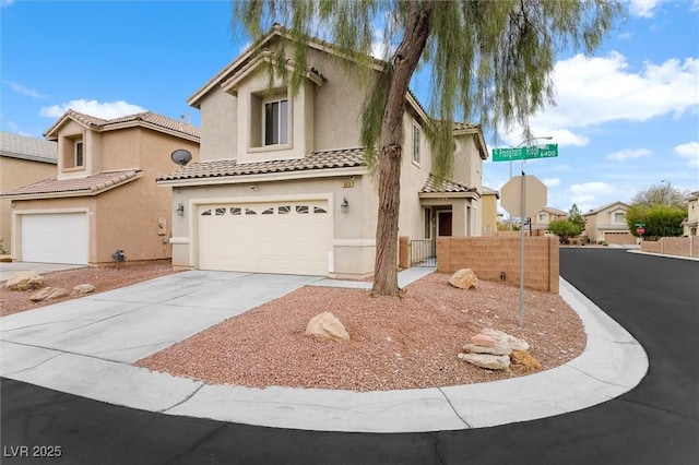 mediterranean / spanish house with fence, stucco siding, concrete driveway, a garage, and a tile roof