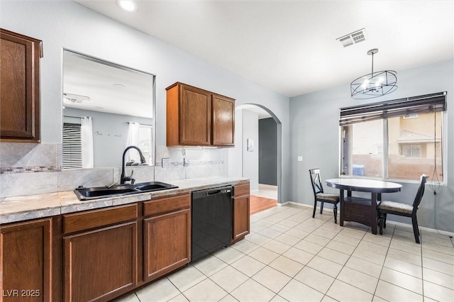 kitchen with visible vents, arched walkways, a sink, light countertops, and dishwasher