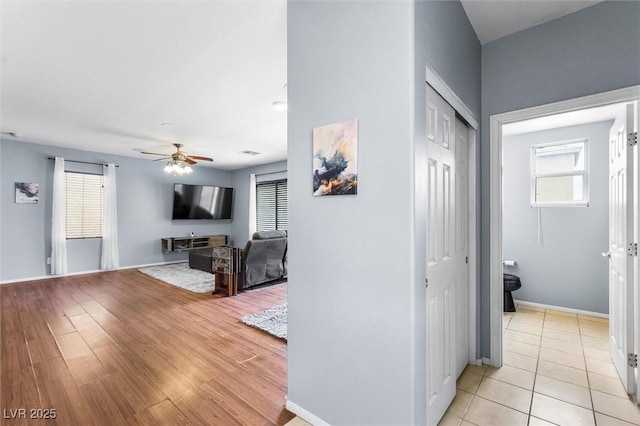 hall with baseboards and light wood-style floors