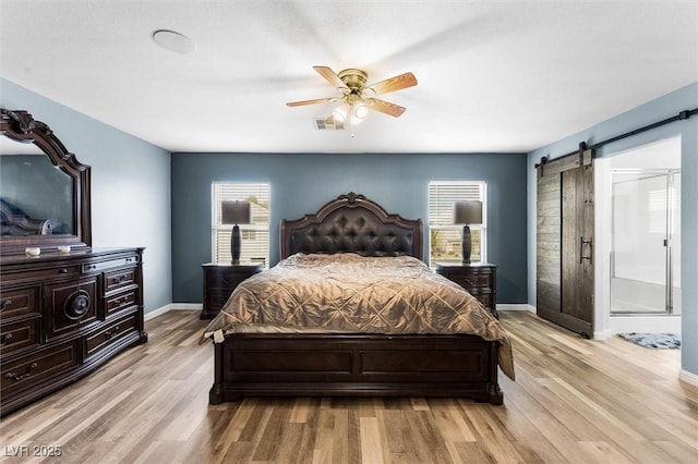 6429 Pronghorn Ridge Ave, Las Vegas, NV 89122 - bedroom featuring a barn door, light wood finished floors, and baseboards