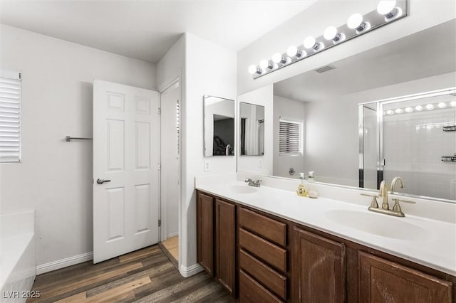 6429 Pronghorn Ridge Ave, Las Vegas, NV 89122 - full bath featuring wood finished floors, double vanity, a shower stall, a bath, and baseboards