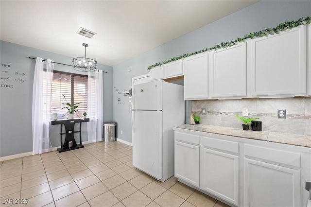 6429 Pronghorn Ridge Ave, Las Vegas, NV 89122 - kitchen with freestanding refrigerator, white cabinetry, light countertops, a chandelier, and tasteful backsplash