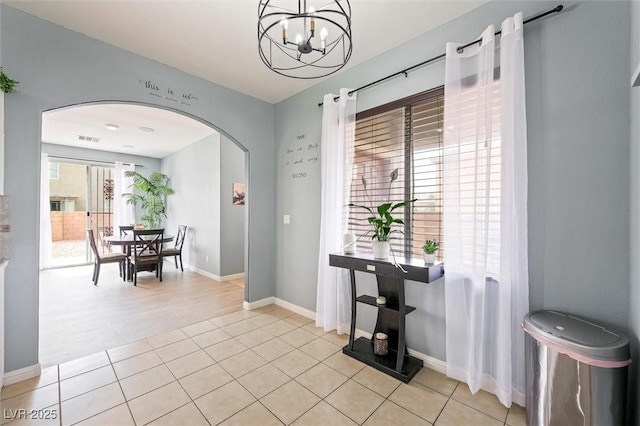 6429 Pronghorn Ridge Ave, Las Vegas, NV 89122 - dining space featuring arched walkways, a chandelier, baseboards, and light tile patterned flooring