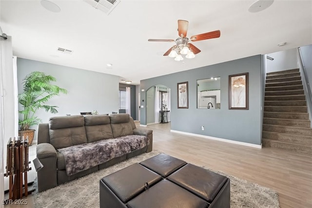 6429 Pronghorn Ridge Ave, Las Vegas, NV 89122 - living area featuring a ceiling fan, light wood-type flooring, arched walkways, and stairs