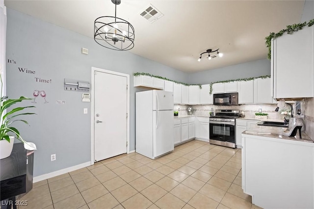 6429 Pronghorn Ridge Ave, Las Vegas, NV 89122 - kitchen with freestanding refrigerator, stainless steel range, black microwave, a sink, and light countertops