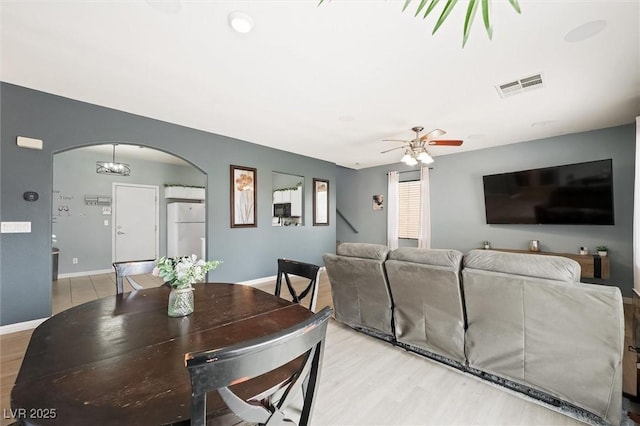 6429 Pronghorn Ridge Ave, Las Vegas, NV 89122 - dining area featuring arched walkways, light wood-style flooring, ceiling fan, and baseboards
