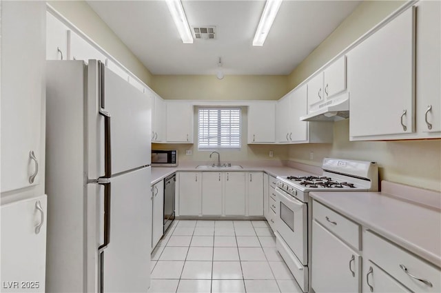 kitchen featuring visible vents, under cabinet range hood, light tile patterned floors, white appliances, and a sink