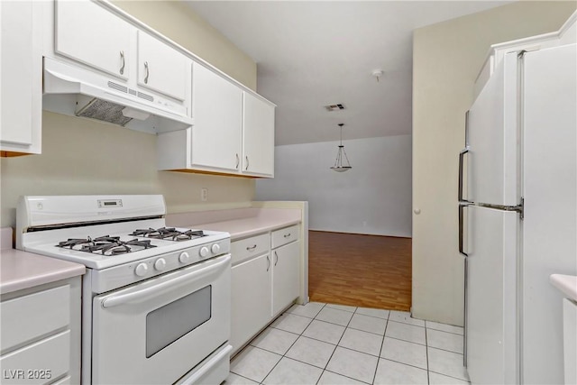 kitchen featuring under cabinet range hood, white cabinetry, white appliances, light countertops, and light tile patterned floors