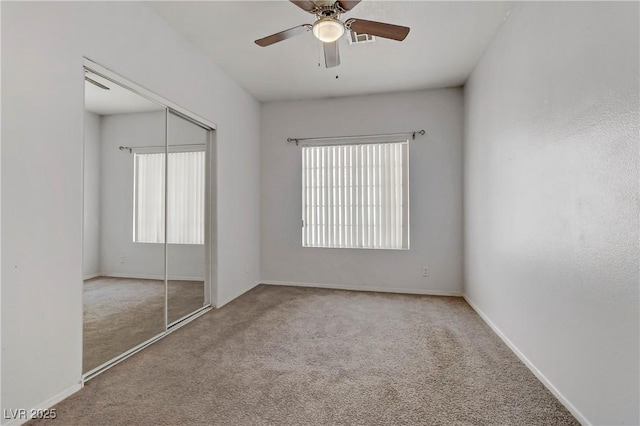 unfurnished bedroom with a closet, baseboards, carpet, and ceiling fan