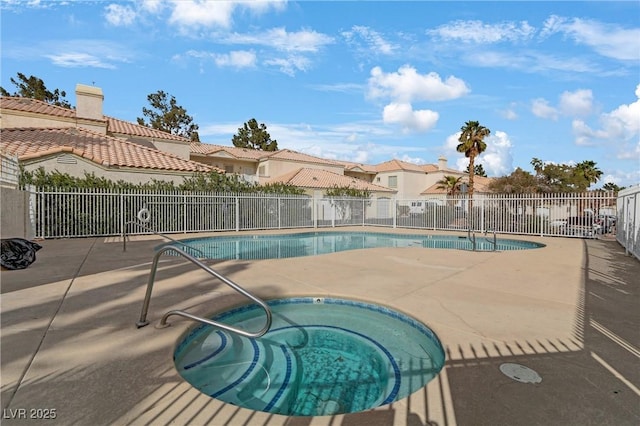 pool with a patio area, a hot tub, and fence