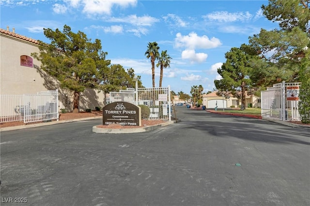 view of road with curbs, a residential view, and a gated entry