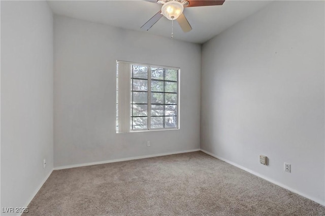 carpeted spare room featuring baseboards and ceiling fan