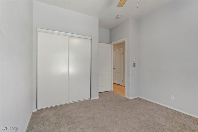 unfurnished bedroom with baseboards, a closet, carpet floors, and ceiling fan