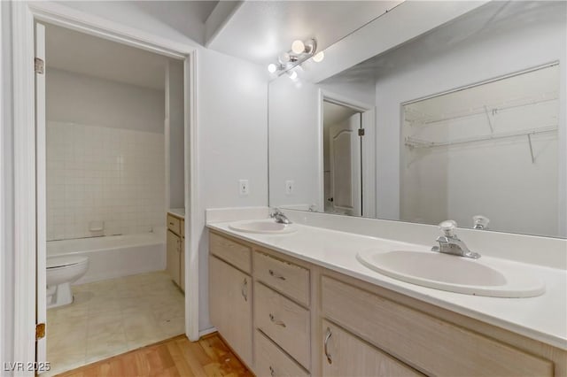 bathroom with a sink, a tub to relax in, and double vanity