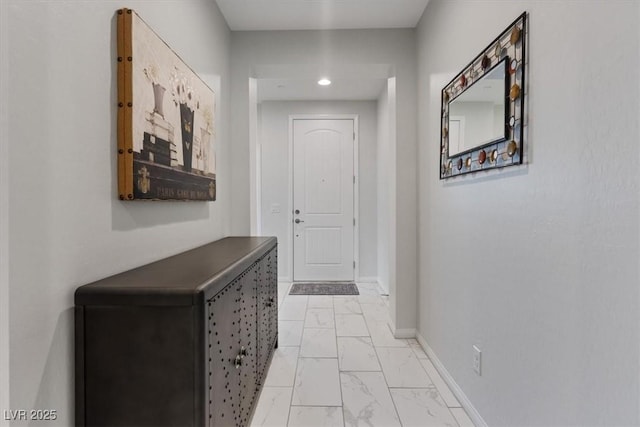 hall featuring marble finish floor and baseboards