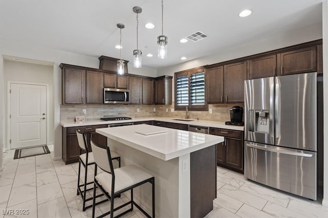 kitchen with visible vents, marble finish floor, a sink, dark brown cabinetry, and appliances with stainless steel finishes