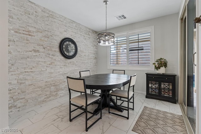 dining area featuring visible vents, baseboards, marble finish floor, and a chandelier