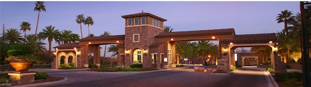 exterior space with curved driveway and a tile roof