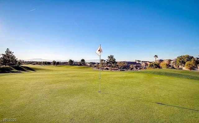 view of home's community with golf course view and a lawn