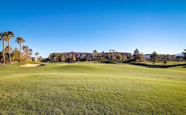 surrounding community featuring a lawn and golf course view