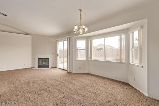 unfurnished living room featuring baseboards, visible vents, a tile fireplace, carpet flooring, and a notable chandelier