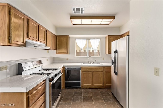 kitchen featuring range with gas cooktop, a sink, stainless steel refrigerator with ice dispenser, under cabinet range hood, and dishwasher