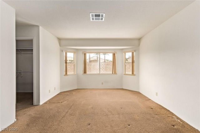 unfurnished bedroom featuring visible vents, carpet floors, a closet, and a walk in closet