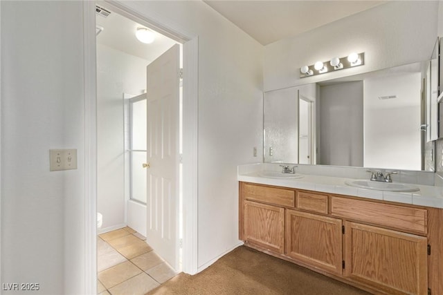 bathroom featuring double vanity, tile patterned flooring, visible vents, and a sink