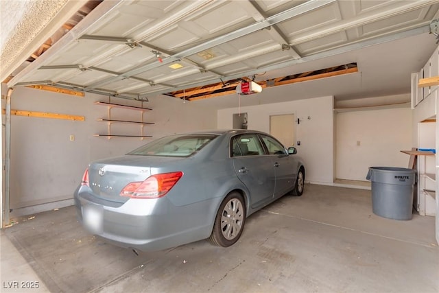 garage with electric panel and a garage door opener