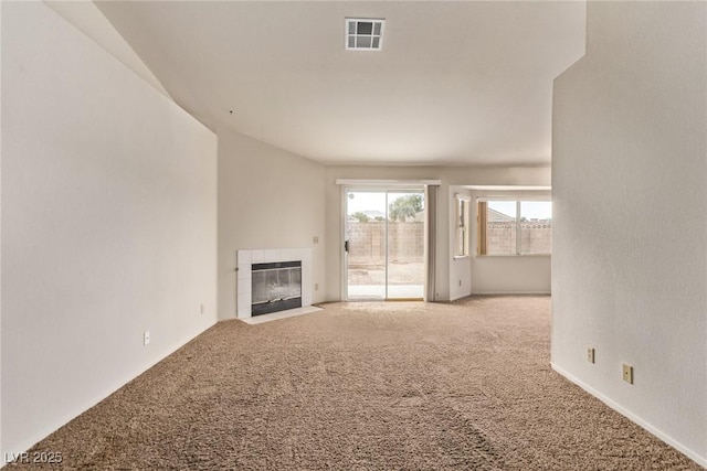 unfurnished living room with carpet flooring, visible vents, and a tile fireplace