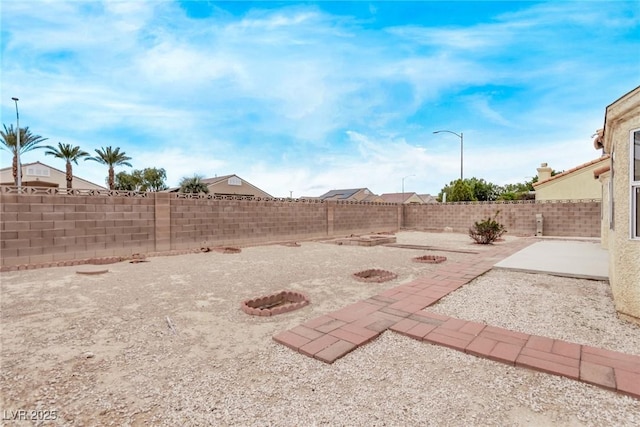 view of yard featuring a patio area, a fire pit, and a fenced backyard