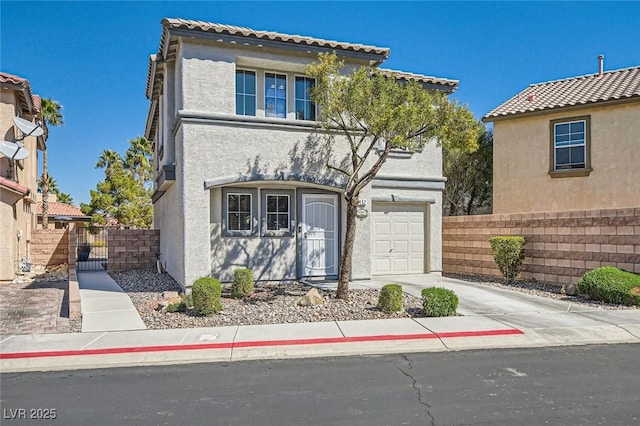 mediterranean / spanish-style house with a gate, fence, driveway, stucco siding, and a garage