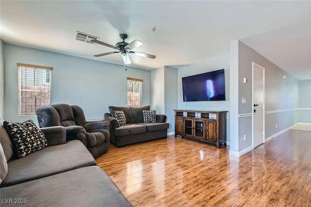 living room featuring wood finished floors, visible vents, a wealth of natural light, and ceiling fan