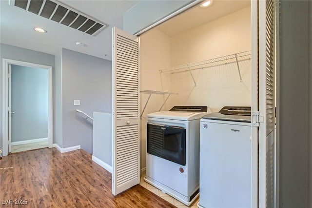 clothes washing area with visible vents, wood finished floors, recessed lighting, separate washer and dryer, and laundry area