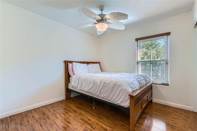 bedroom featuring wood finished floors, baseboards, and ceiling fan